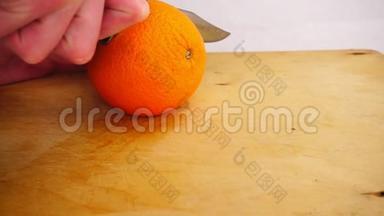 用刀子在木砧板上切开鲜橙，动作缓慢